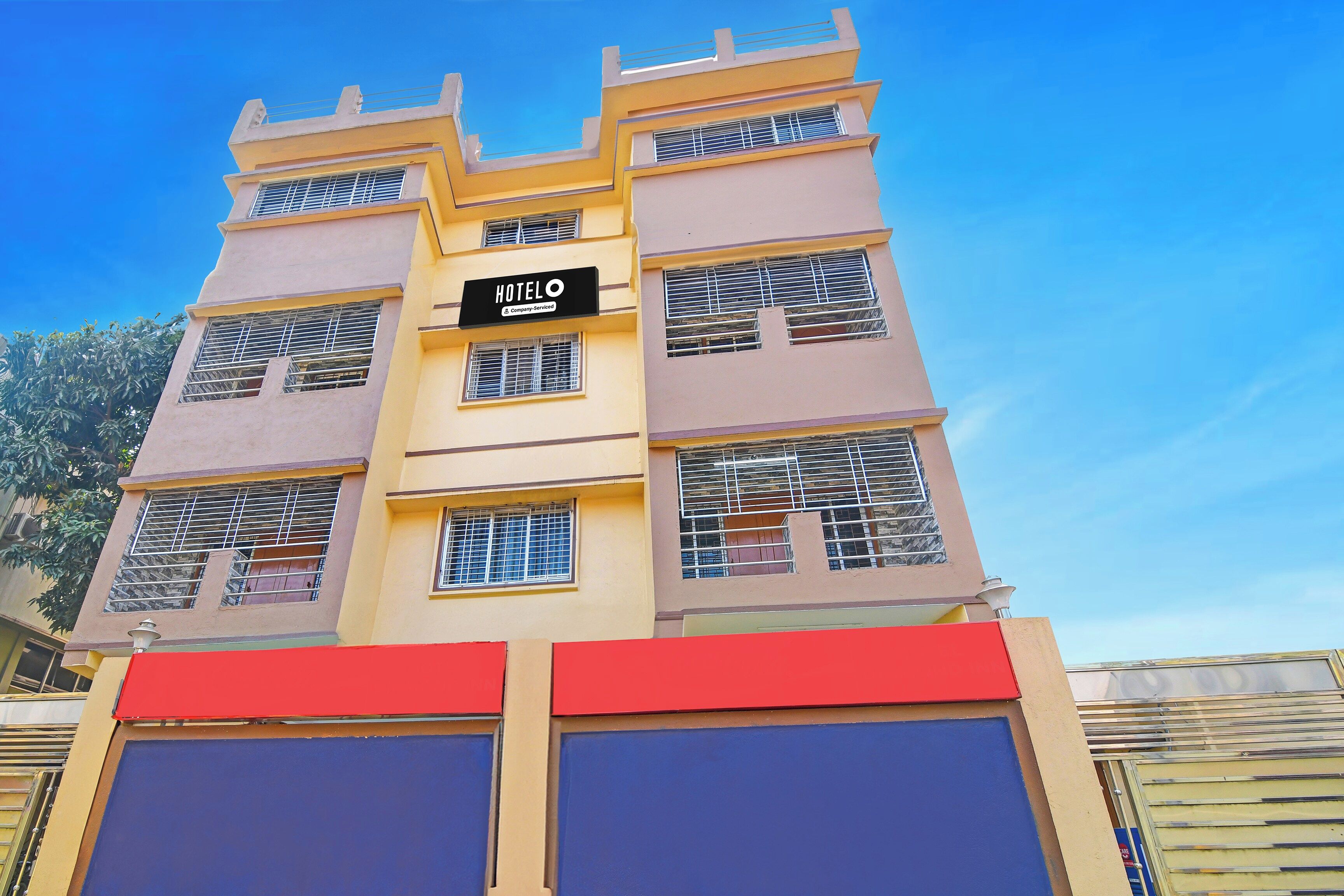 A multi-story hotel building with a sign indicating it is a company-serviced hotel.