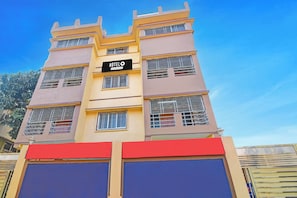A multi-story hotel building with a sign indicating it is a company-serviced hotel.