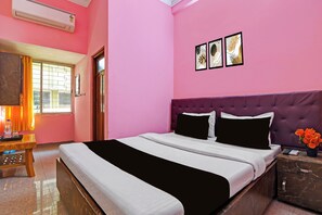 Una camera da letto con un letto, un comodino, uno specchio e una finestra con tende.