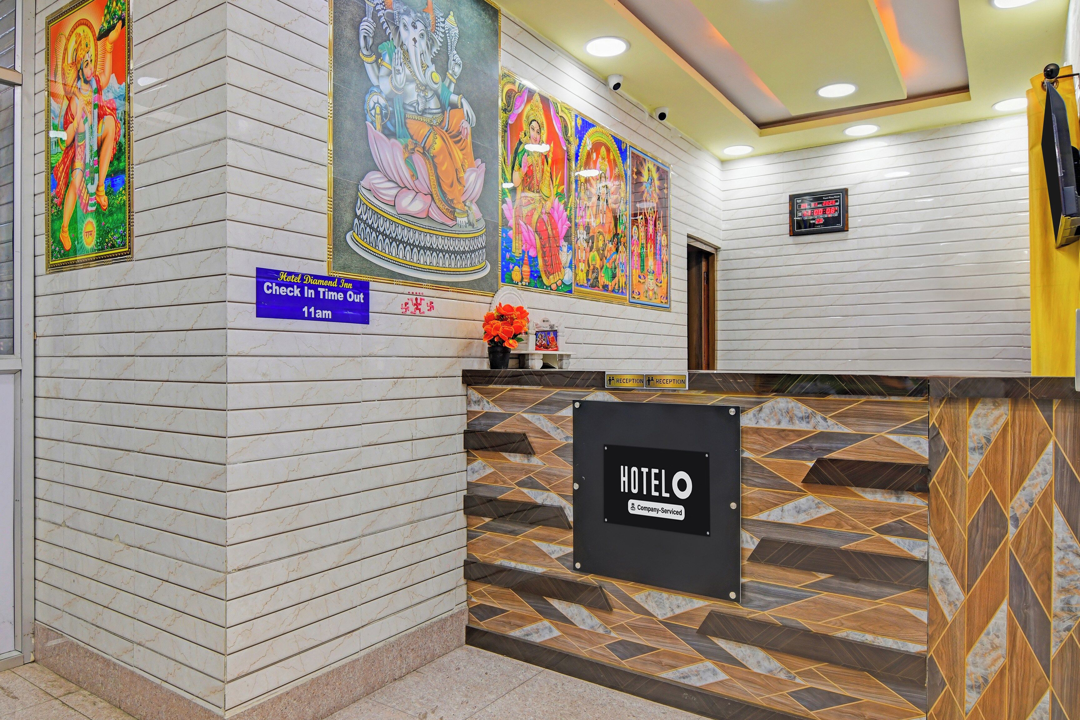 A hotel reception area with marble walls, a check-in sign, and a digital clock.