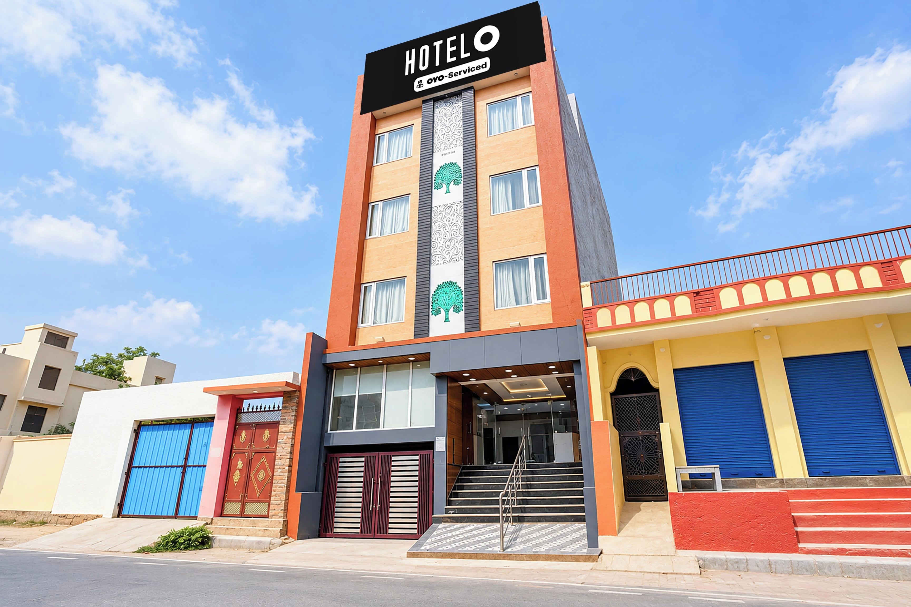 Un hotel con un letrero llamativo, una escalera que conduce a la entrada y una fachada moderna.