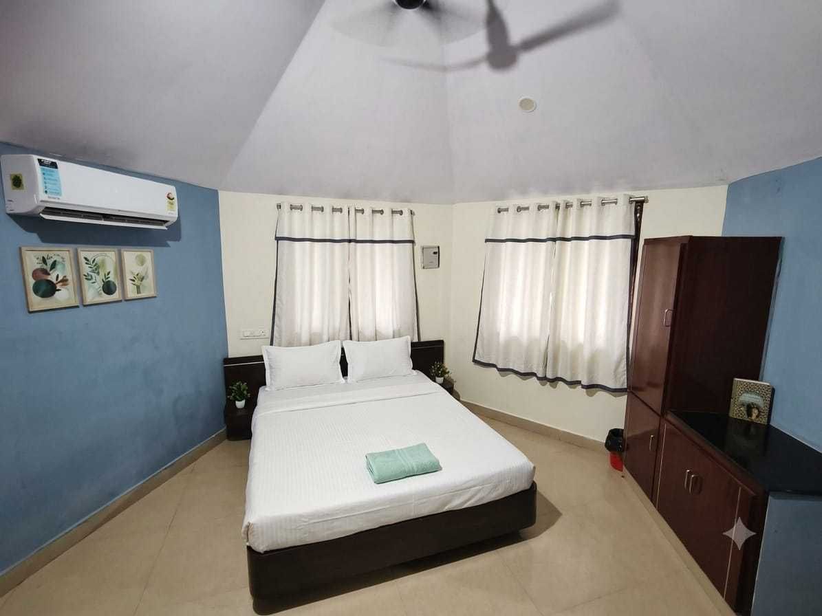 Ein Schlafzimmer mit Bett, Vorhängen, Klimaanlage, Kleiderschrank und Deckenventilator.