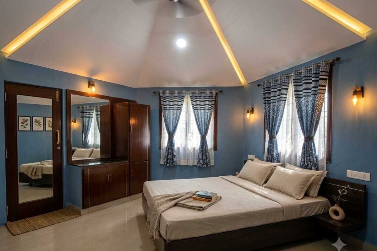 A bedroom with a bed, bedside tables, a wardrobe, and curtains.