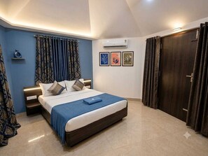 A bedroom with a bed, curtains, a wardrobe, and wall art. - Collection O Srikakulam (Laveru)