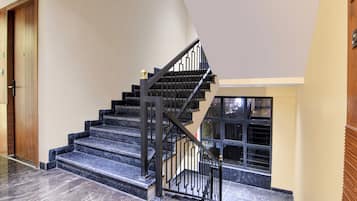 A staircase with black railings and marble steps, leading to an upper floor.