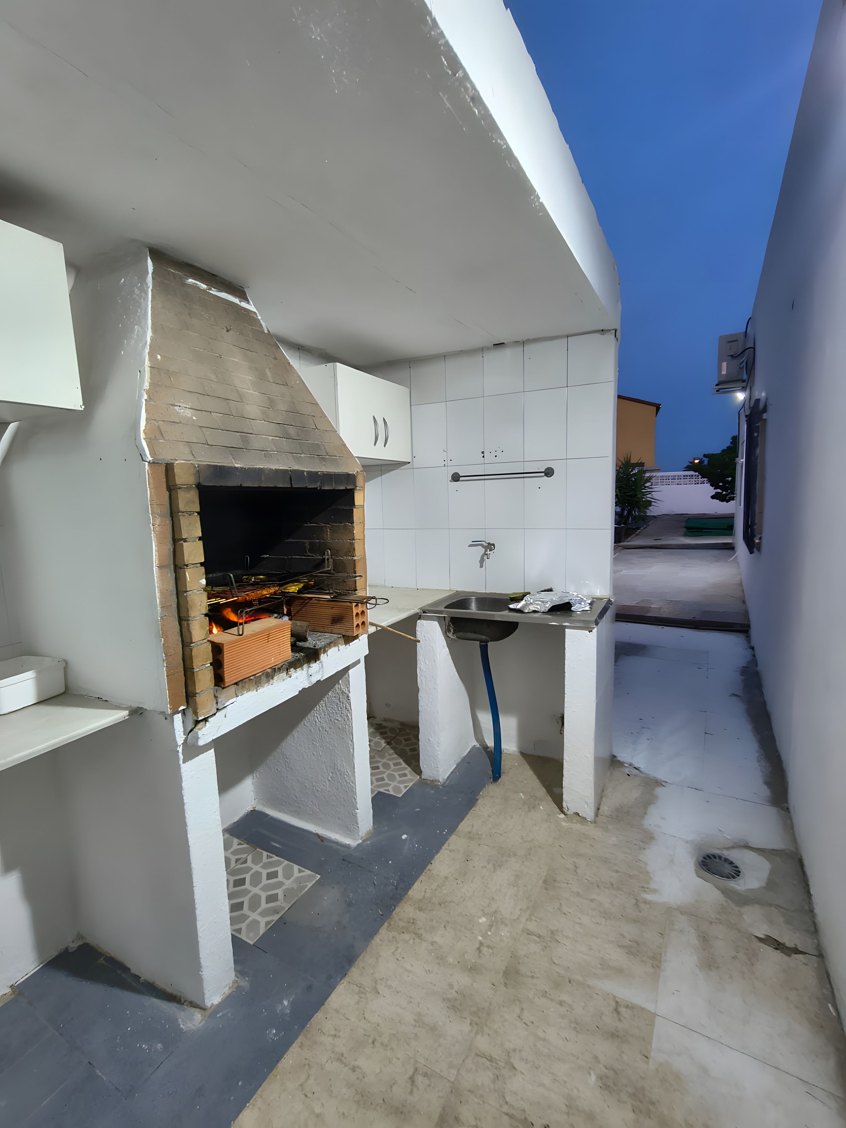 A compact kitchen with a built-in grill, a sink, and a small countertop.