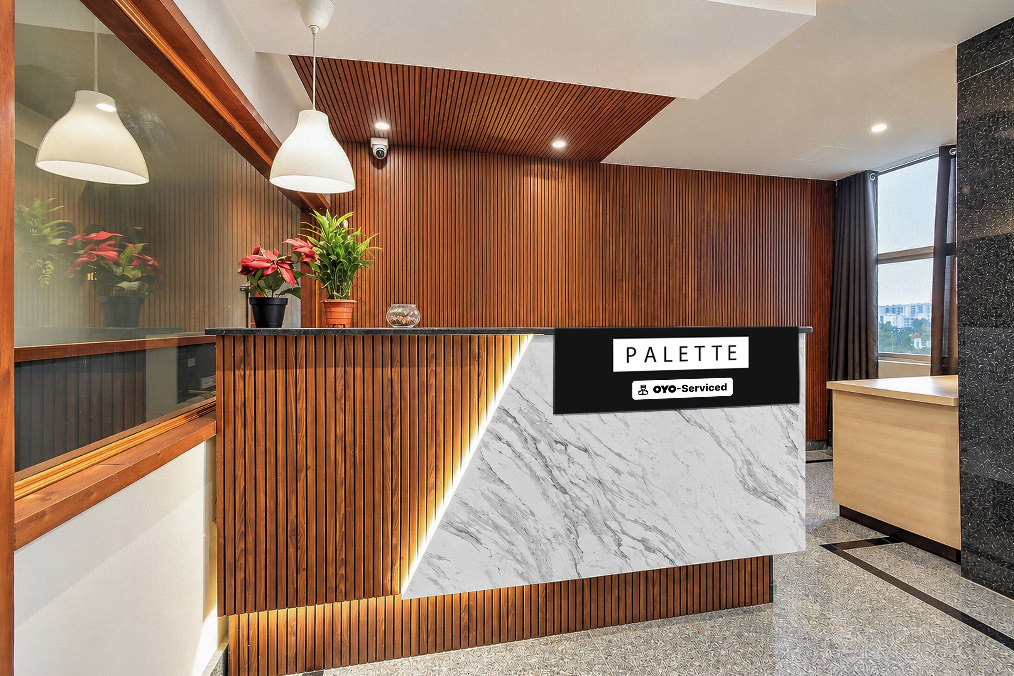 A reception desk with a wooden panel design and a marble counter.