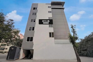 A modern hotel building with a sign indicating it is company-serviced.