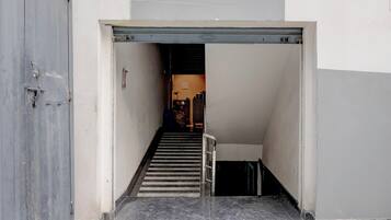 Una escalera estrecha que lleva a una sección superior con una puerta a la izquierda y otra escalera a la derecha.