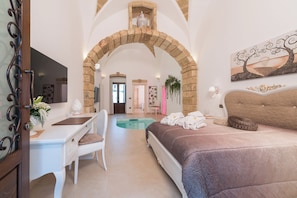 A bedroom with a bed, a desk, and a chair. There is a pool in the background. - New Listing (Alliste)