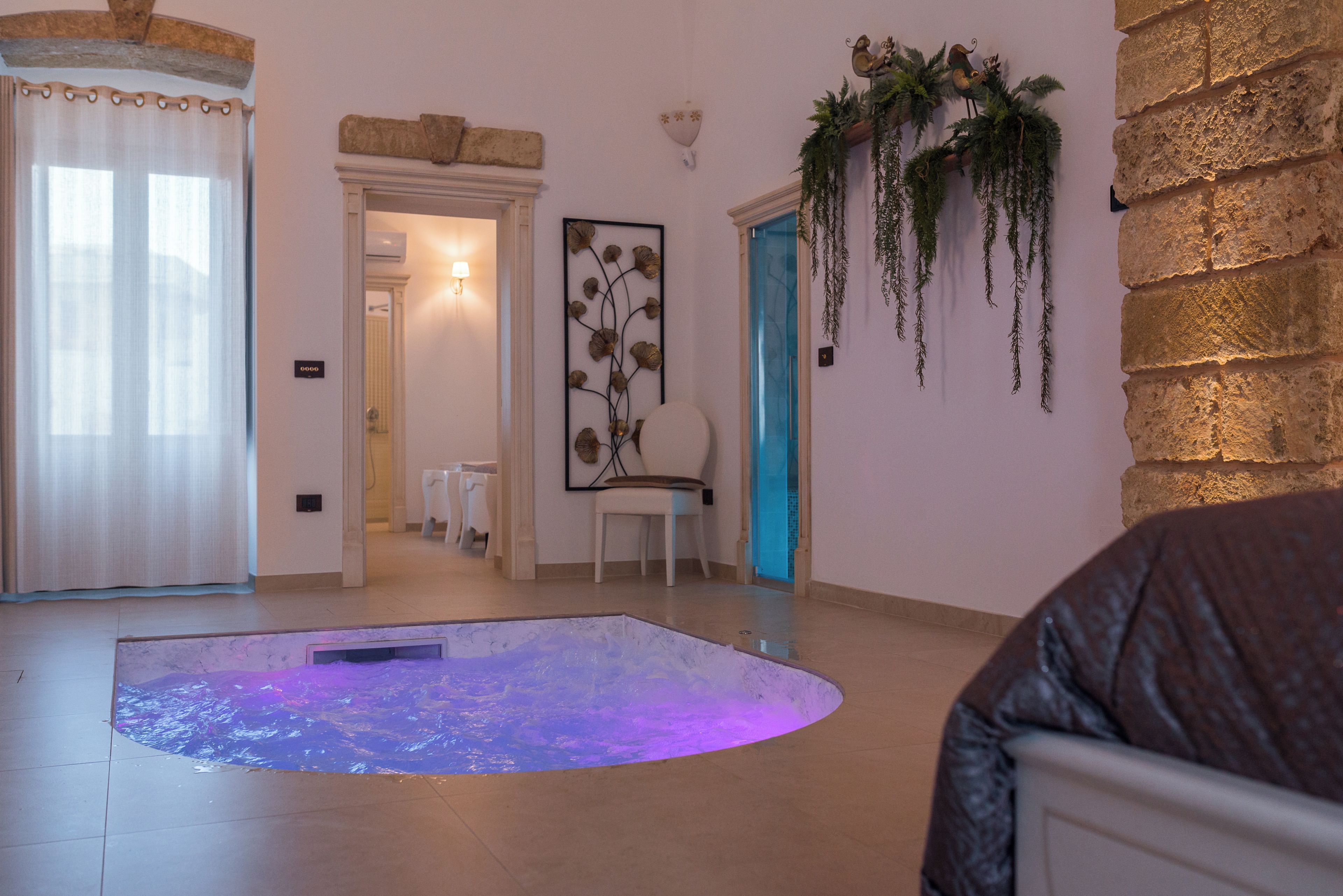A room with a marble floor, a white chair, a wall-mounted plant, and a framed artwork.