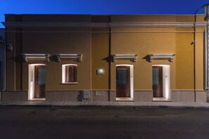 A building facade with three doorways, each with a window above.