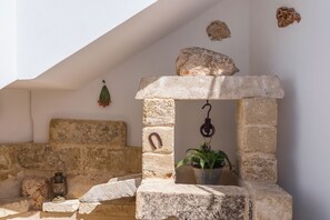 A stone bench with a lantern, a stone wall, and a hanging plant. - New Listing (Alliste)