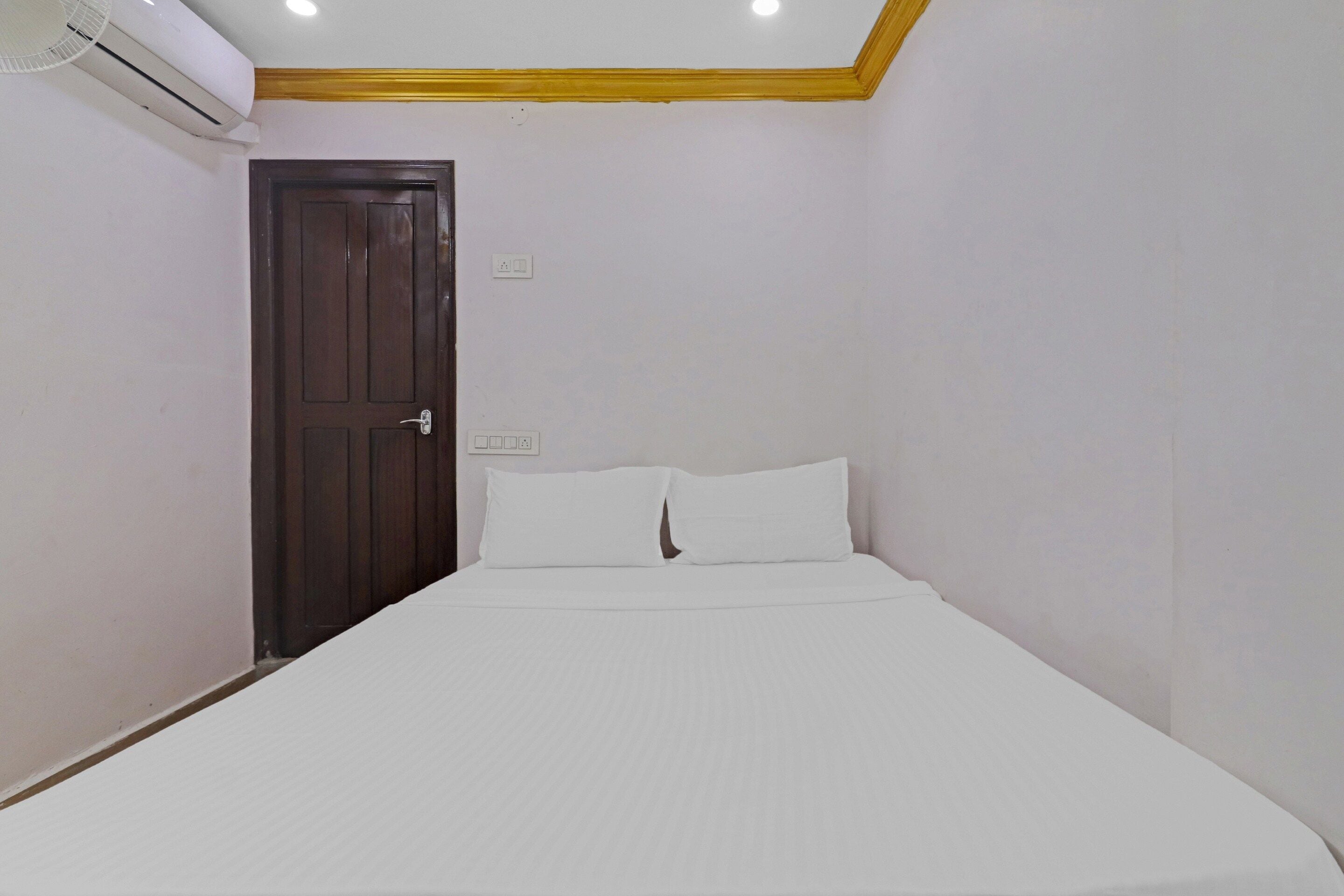 Un dormitorio con una cama individual, una puerta y un equipo de aire acondicionado.