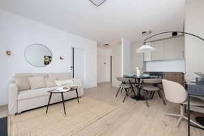 A modern apartment with a living room, dining area, and kitchenette. - Comfortable Apartment in Warsaw with Workspace by Noclegi Renters (Warszawa)