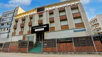 Un edificio de varios pisos con un letrero que indica 'GOVIND PLAZA' y 'TOUMHOUSE OAK', con la etiqueta de servicio de empresa.