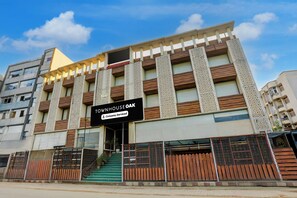 Un edificio de varios pisos con un letrero que indica 'GOVIND PLAZA' y 'TOUMHOUSE OAK', con la etiqueta de servicio de empresa.