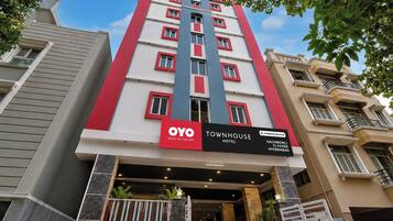 Een meerlaags hotel met een opvallende rode en witte gevel, een bord met de OYO merknaam, en een locatie in Hyderabad.