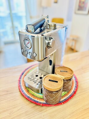 A coffee machine with a pressure gauge and a knob, placed on a woven placemat with two wooden containers labeled 'COFFEE'. - New Listing (Catania)