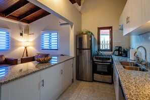 A modern kitchen with a stainless steel refrigerator, a gas stove, and a built-in oven.