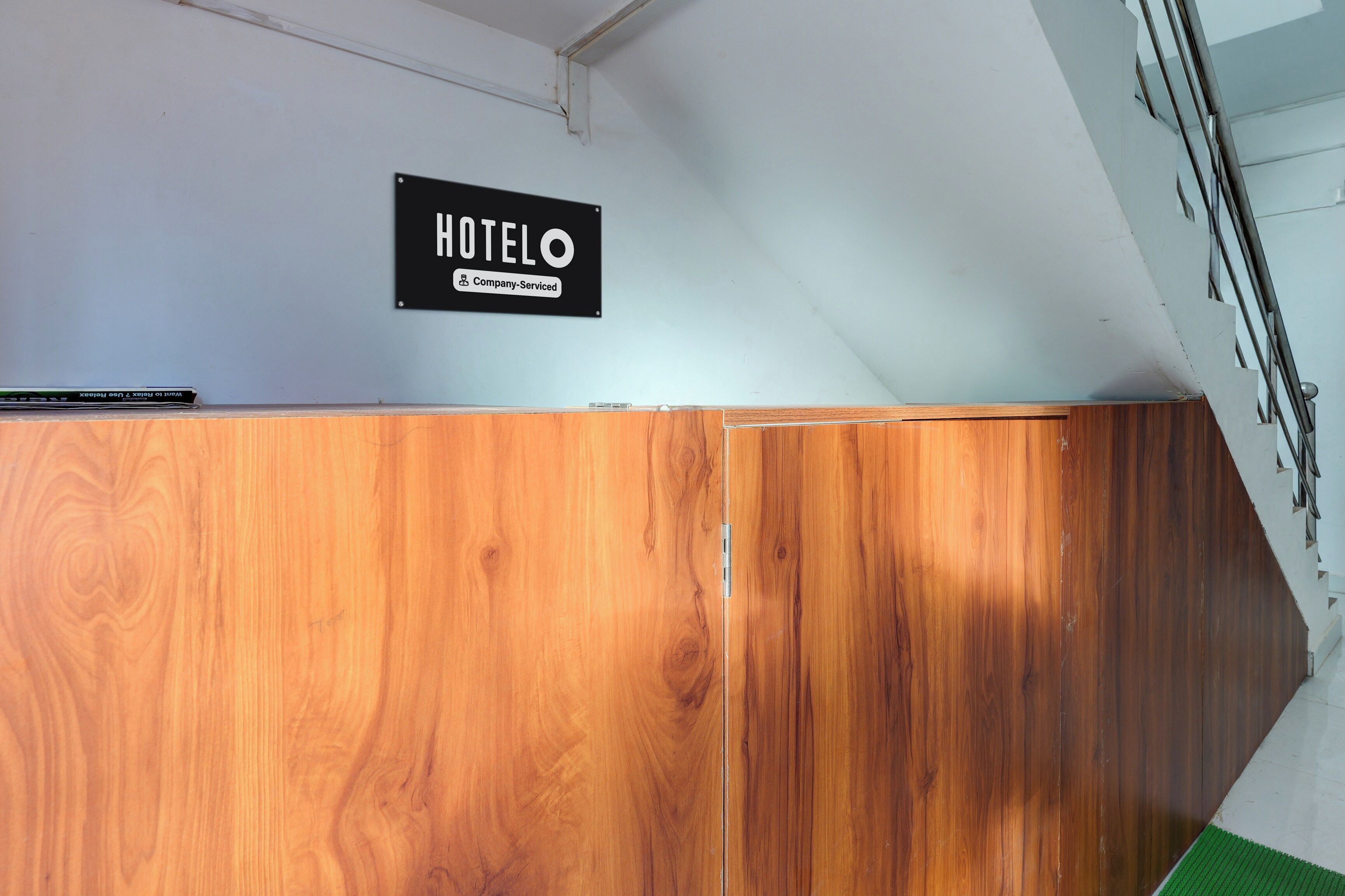 Un mostrador de recepción de madera con un cartel que dice 'HOTELO Company-Serviced'.