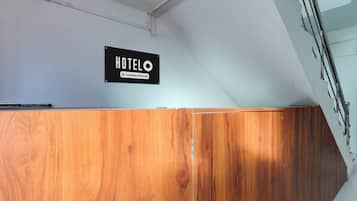 Un mostrador de recepción de madera con un cartel que dice 'HOTELO Company-Serviced'.