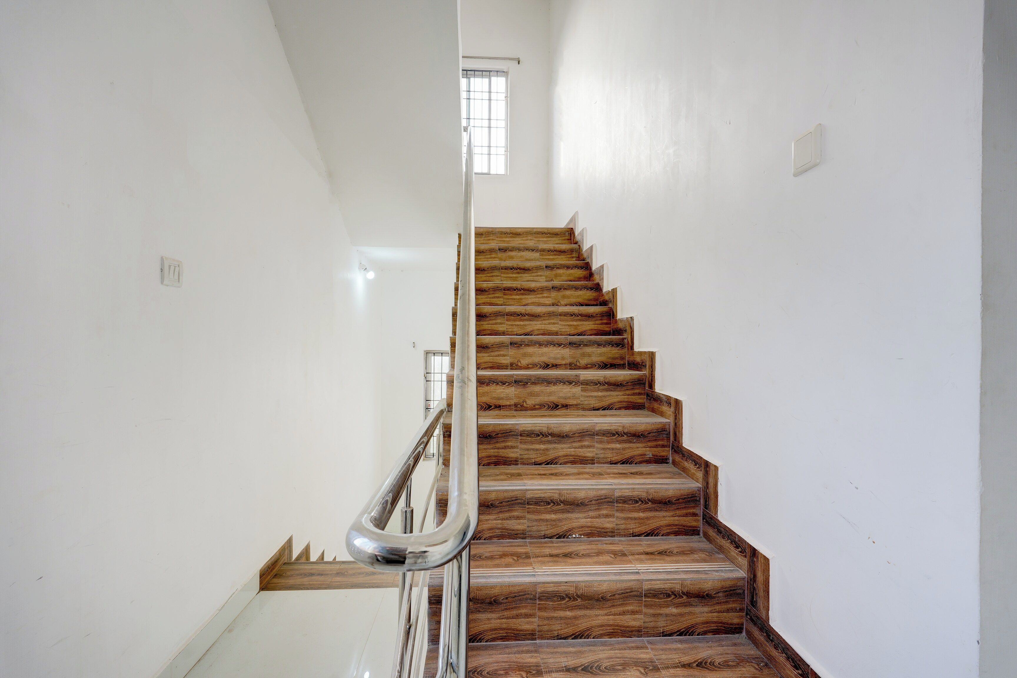 Una escalera con escalones de madera y barandilla de metal.