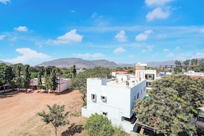 A residential area with modern buildings, a clear sky, and distant mountains.
