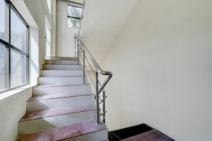 Una escalera con barandillas de metal que lleva a un rellano.