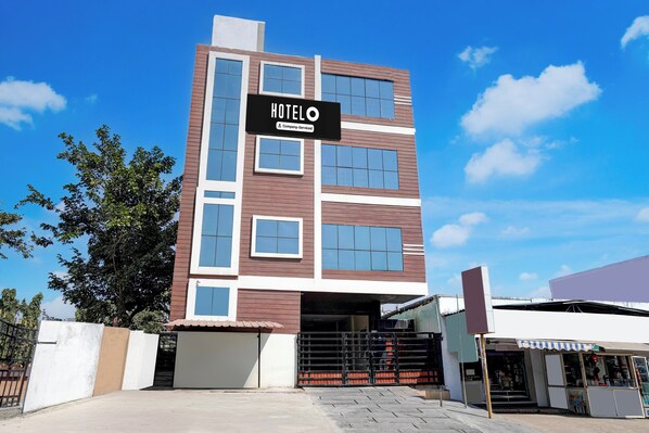 A multi-story hotel with a prominent sign reading 'HOTEL' and 'Company Serviced.'