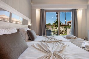 A hotel room with a bed, a large window, and a view of the outside. - Apartment 'Paradise Zante One Bedroom Suite 2' with Shared Pool, Wi-Fi and Air Conditioning (Αγριλιά)
