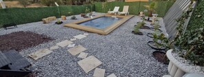 A pool area with a rectangular pool, surrounded by pebbles and potted plants. - Charming Bungalow with Private Hot Pool in Seferihisar, Türkiye (Seferihisar)