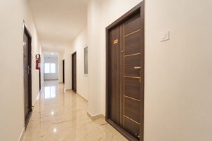 A hallway with a fire extinguisher, a door labeled '202', and a window at the end.
