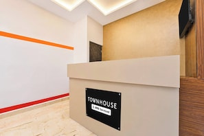 A reception desk with a sign indicating it is serviced by Oyo. - Townhouse Erode Bus Terminal (Erode)