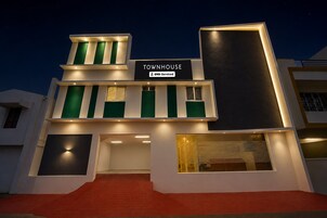 A modern townhouse with a sign indicating it is serviced by OYO.