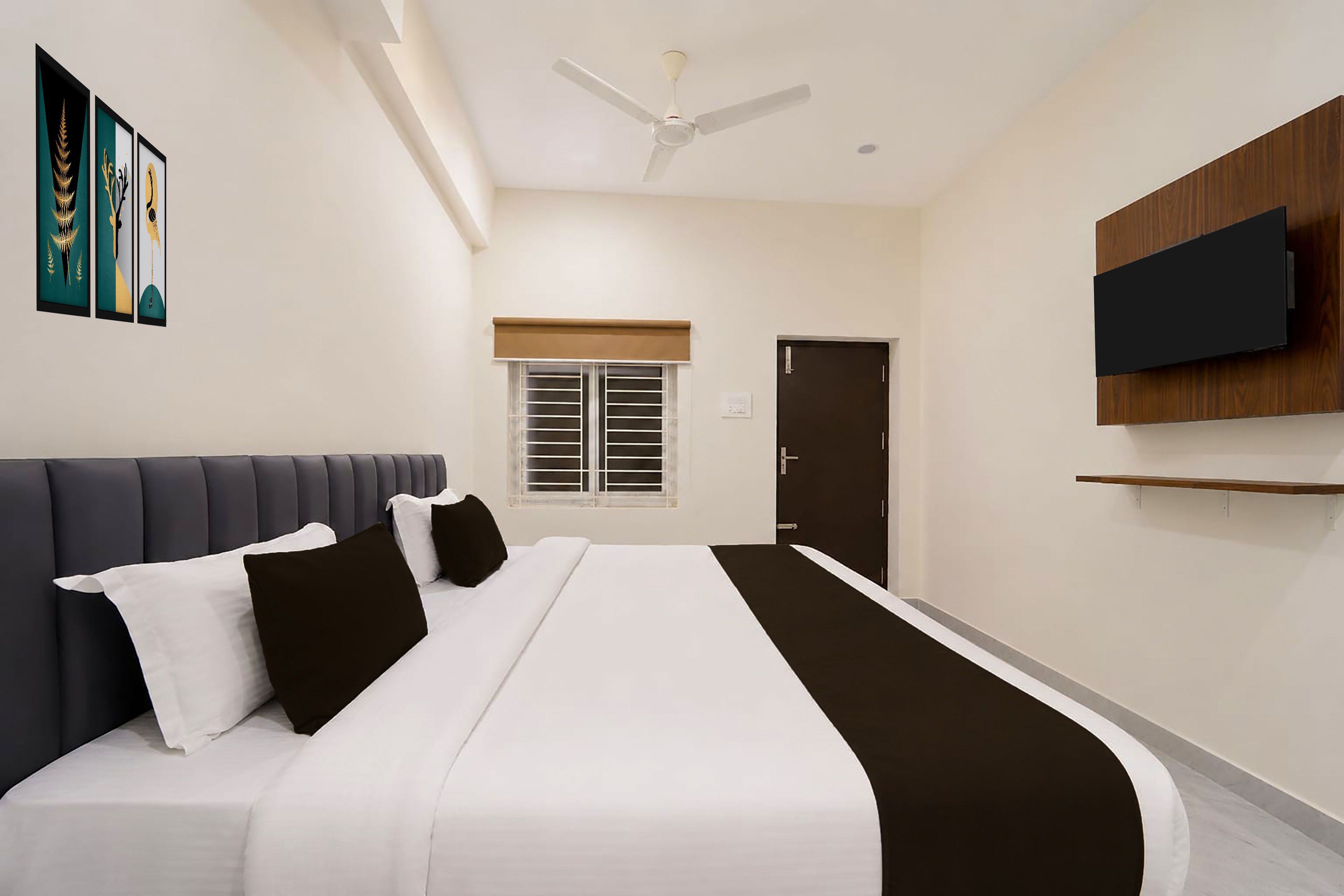 Una habitación de hotel moderna con una cama, un ventilador de techo, un televisor montado en la pared y una ventana con persianas.