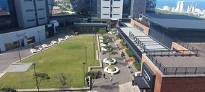 A modern building with a flat roof, a central courtyard with a lawn, and a seating area with circular planters. - Luxurious 2-Bedroom Apartment in uMhlanga, South Africa (uMhlanga)