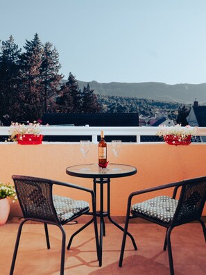 A terrace with two chairs, a table, and a bottle of wine. - Hvar spa & Apartments-1 Bedroom-balcony/sea View 5 (Jelsa)