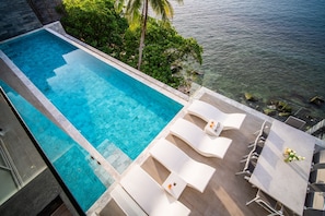 A rooftop infinity pool with clear water, surrounded by lounge chairs and a view of the ocean. - Kamala Beach frontline sea view villa (Kamala, Kathu District,)
