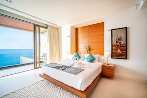 A modern hotel room with a large bed, a view of the sea, and a wooden headboard. - Kamala Beach frontline sea view villa (Kamala, Kathu District,)