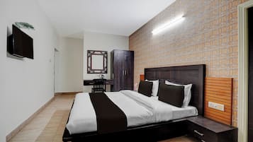 A modern bedroom with a bed, bedside table, and a wall-mounted TV.