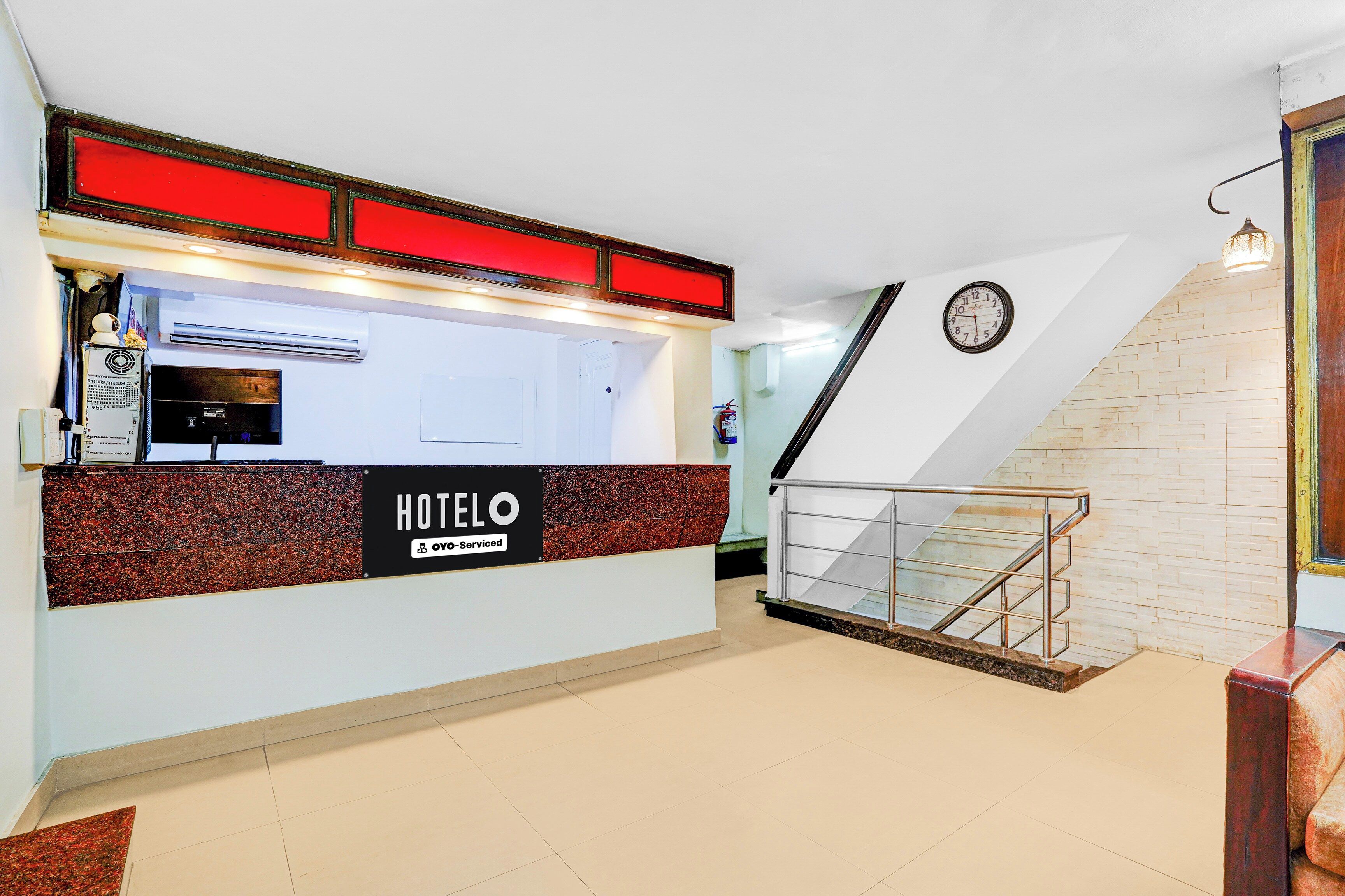 A hotel reception area with a sign indicating it is 'Oyo-Serviced.'