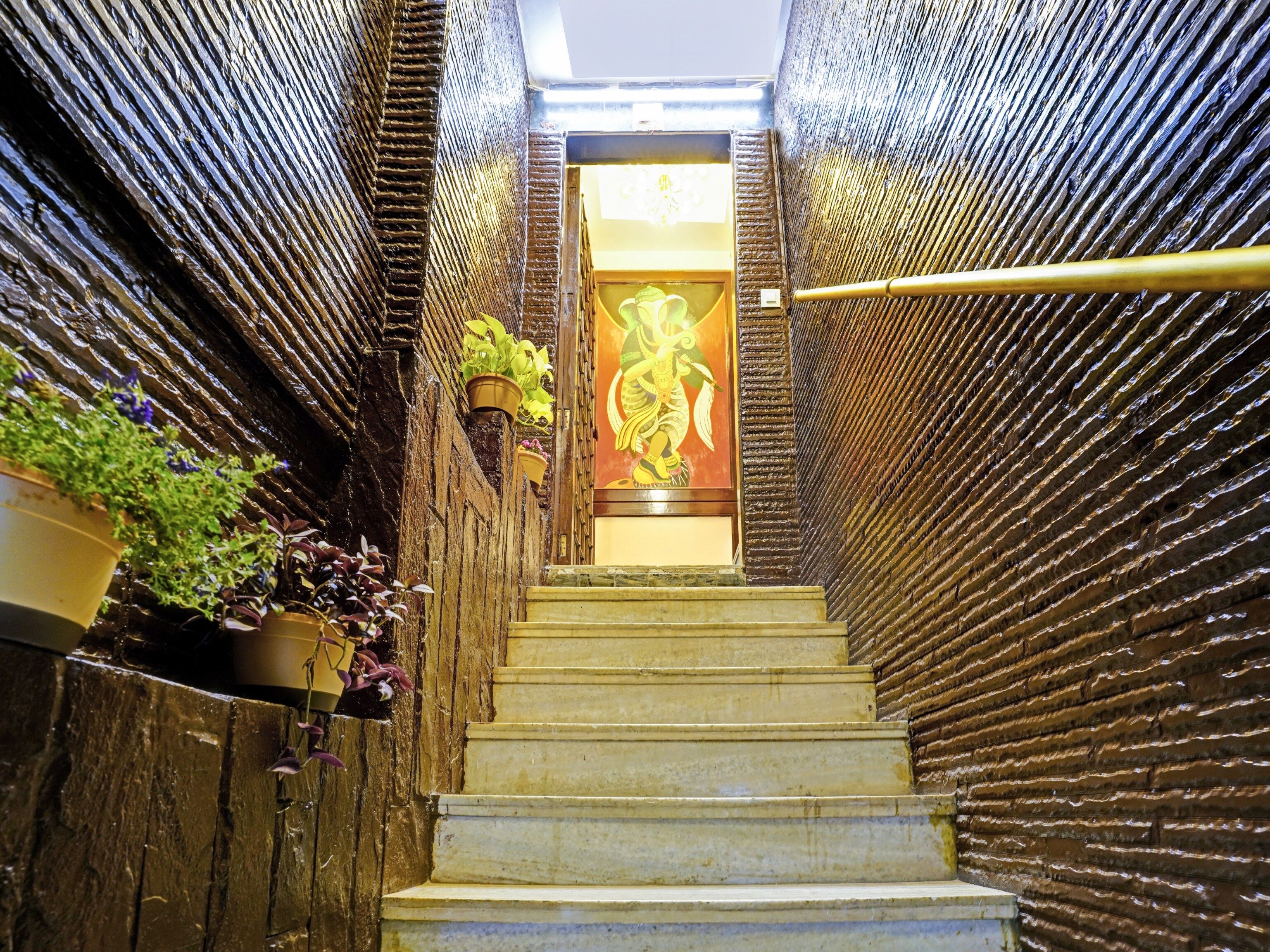 A staircase with a textured wall on either side, leading to a door with a decorative panel.