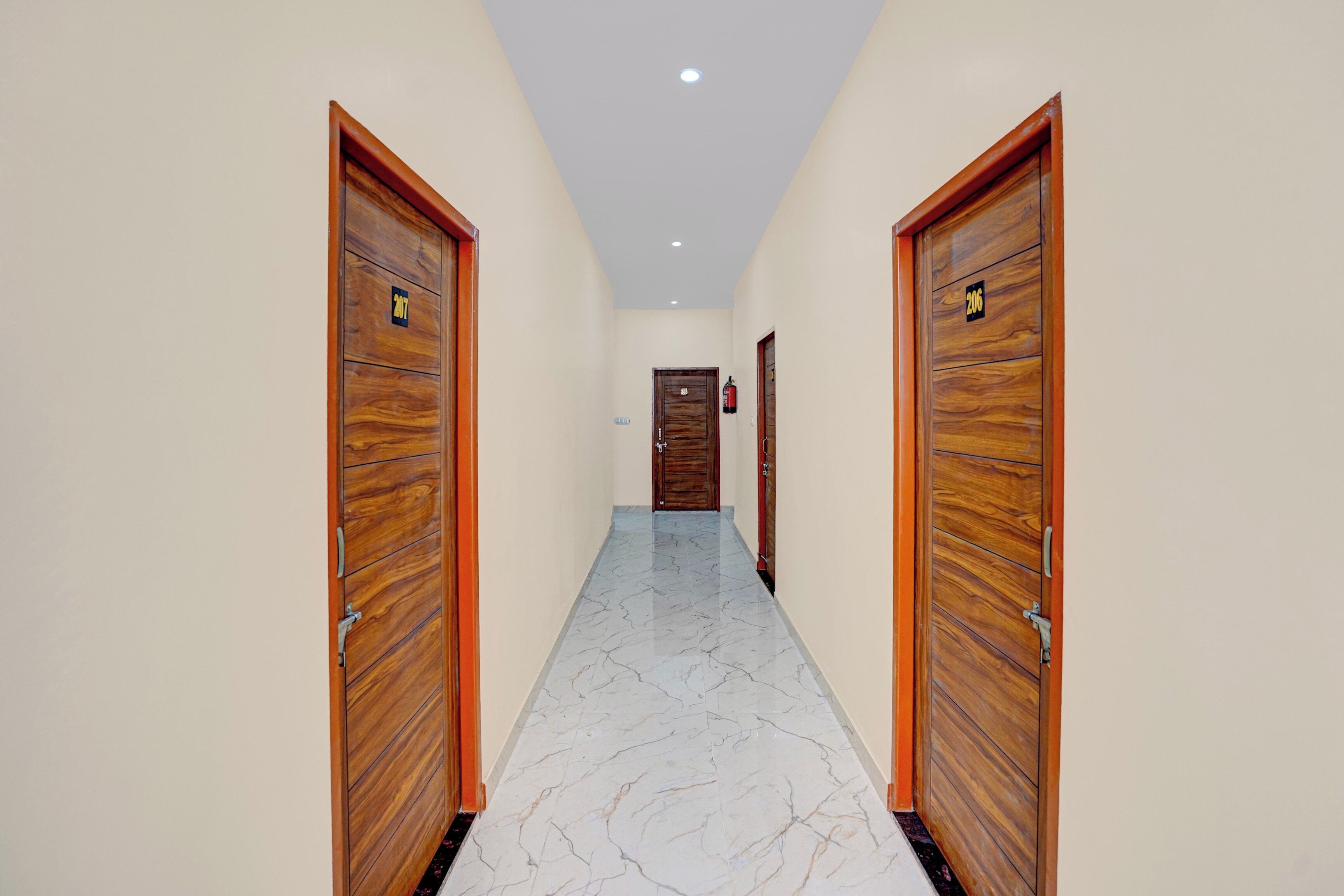 Un pasillo con puertas de madera y suelo de mármol.