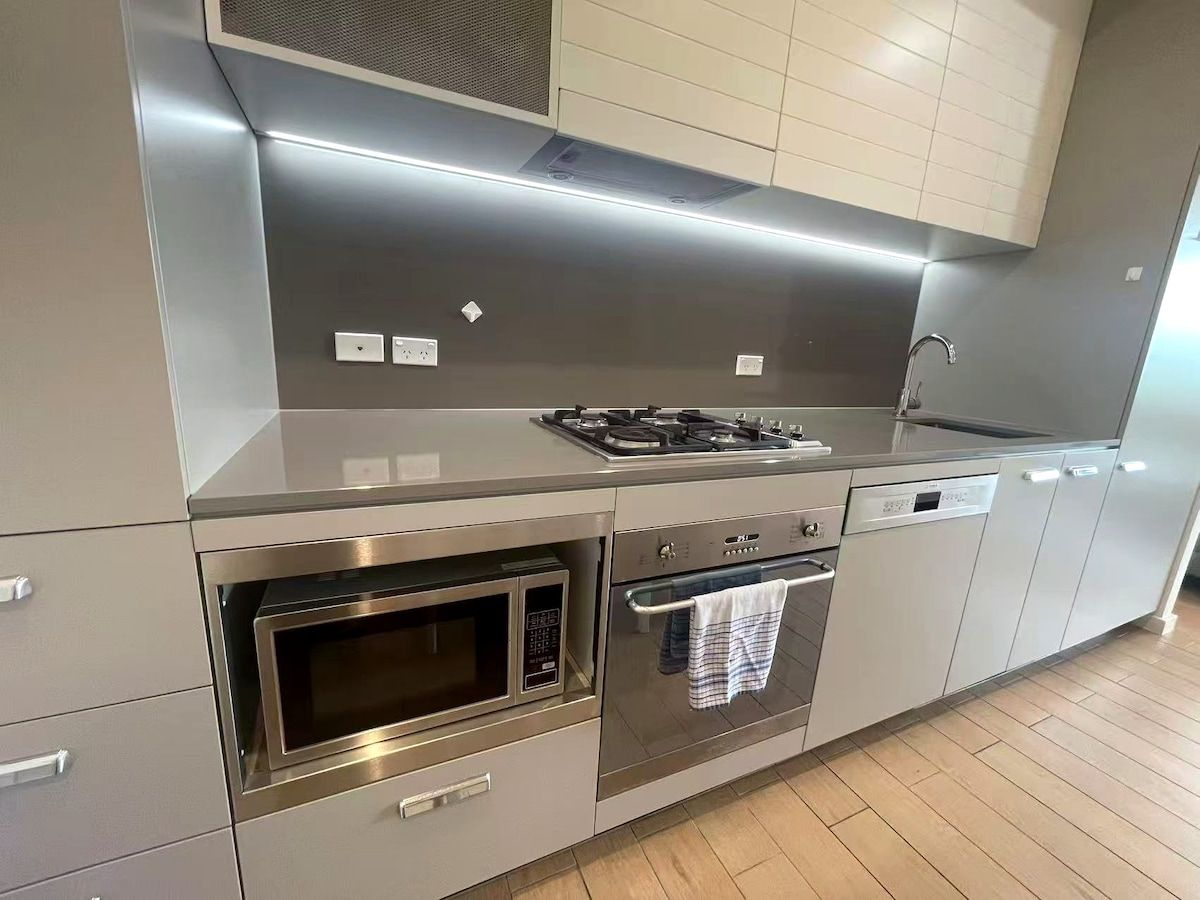 A modern kitchen with stainless steel appliances, including a microwave, oven, and dishwasher.