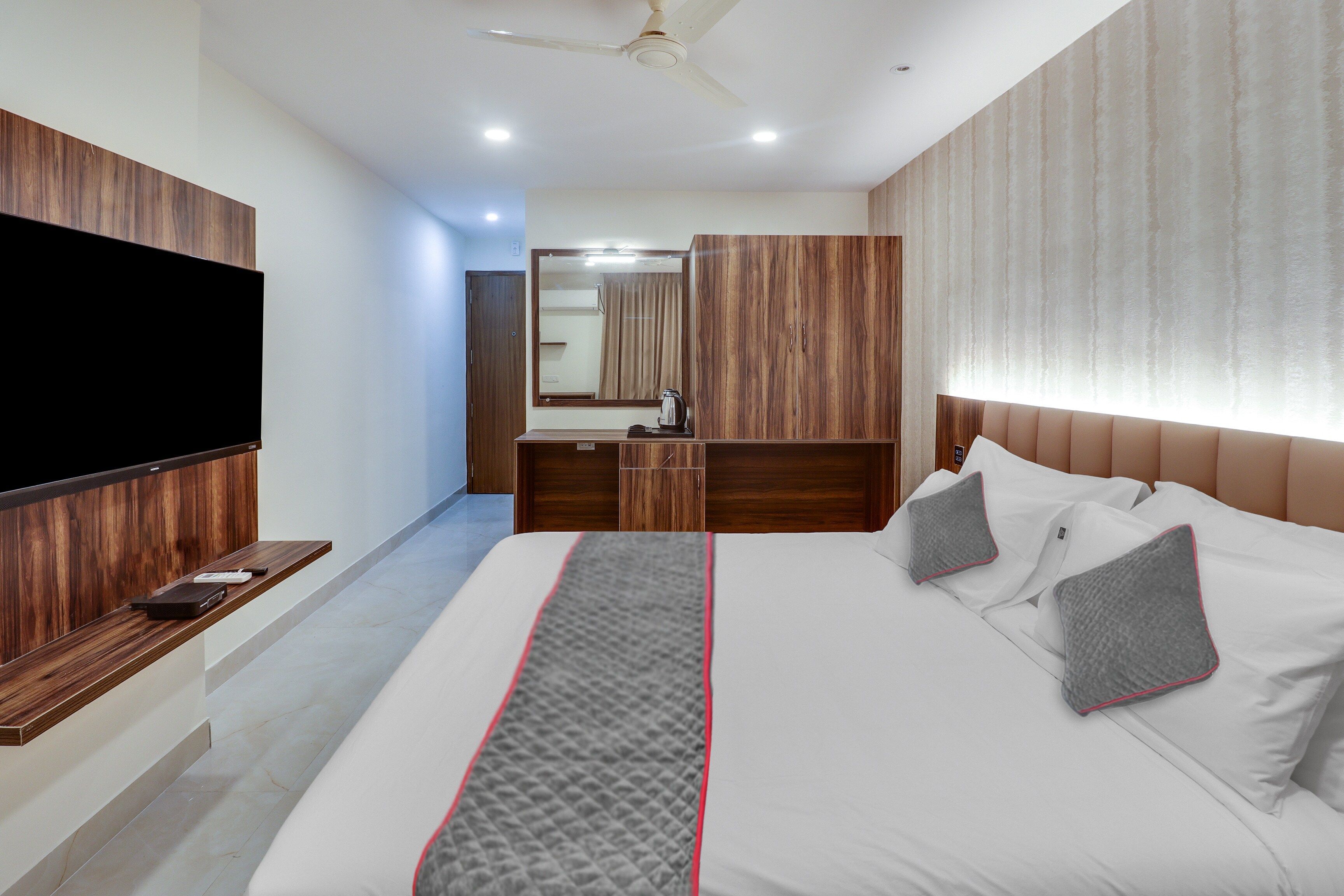 Una habitación de hotel con cama, televisión, escritorio y armario.