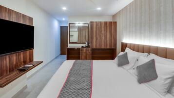 Una habitación de hotel con cama, televisión, escritorio y armario.
