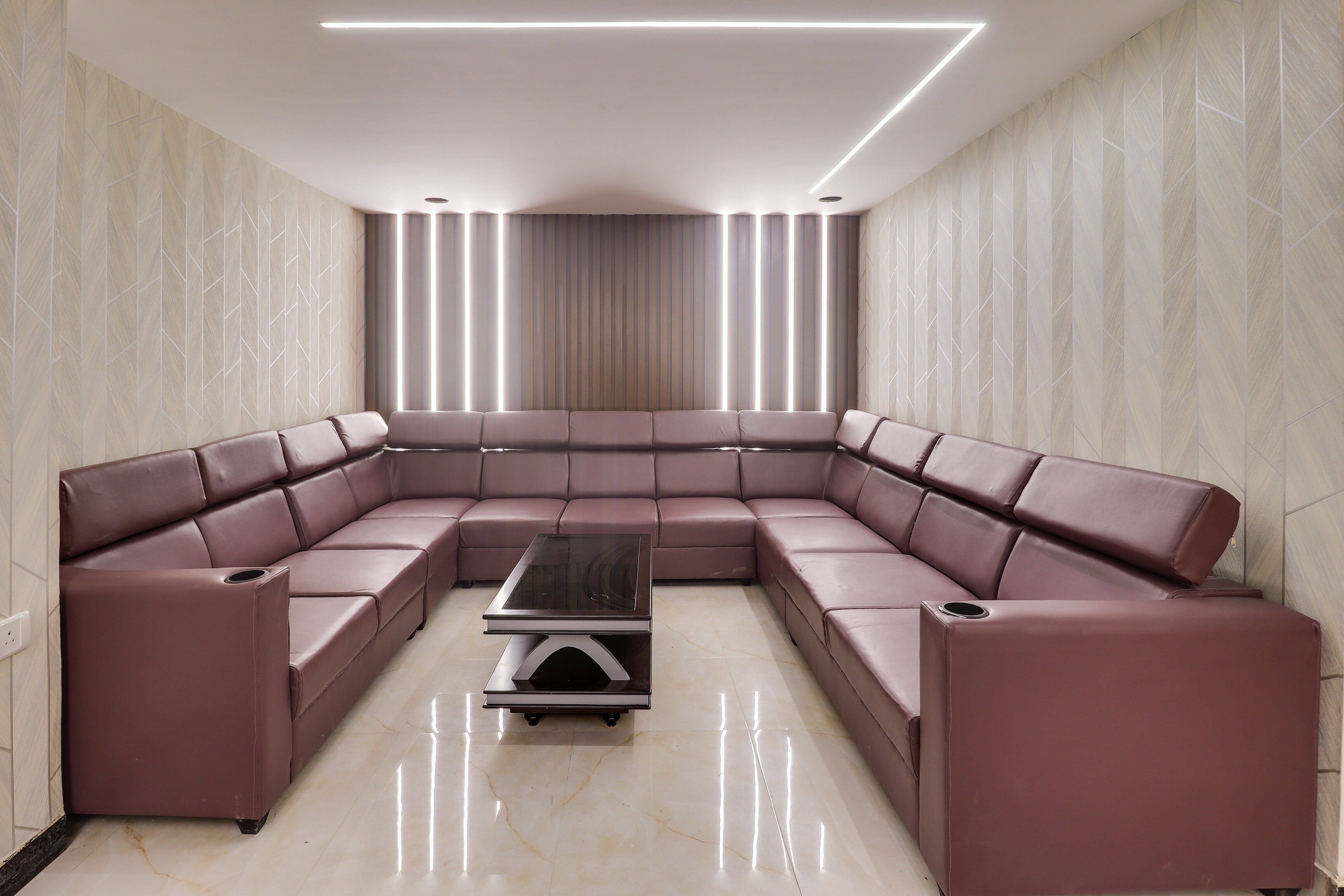 Una sala de estar moderna con un sofá seccional en forma de L, una mesa de centro de vidrio y una paleta de colores neutros.