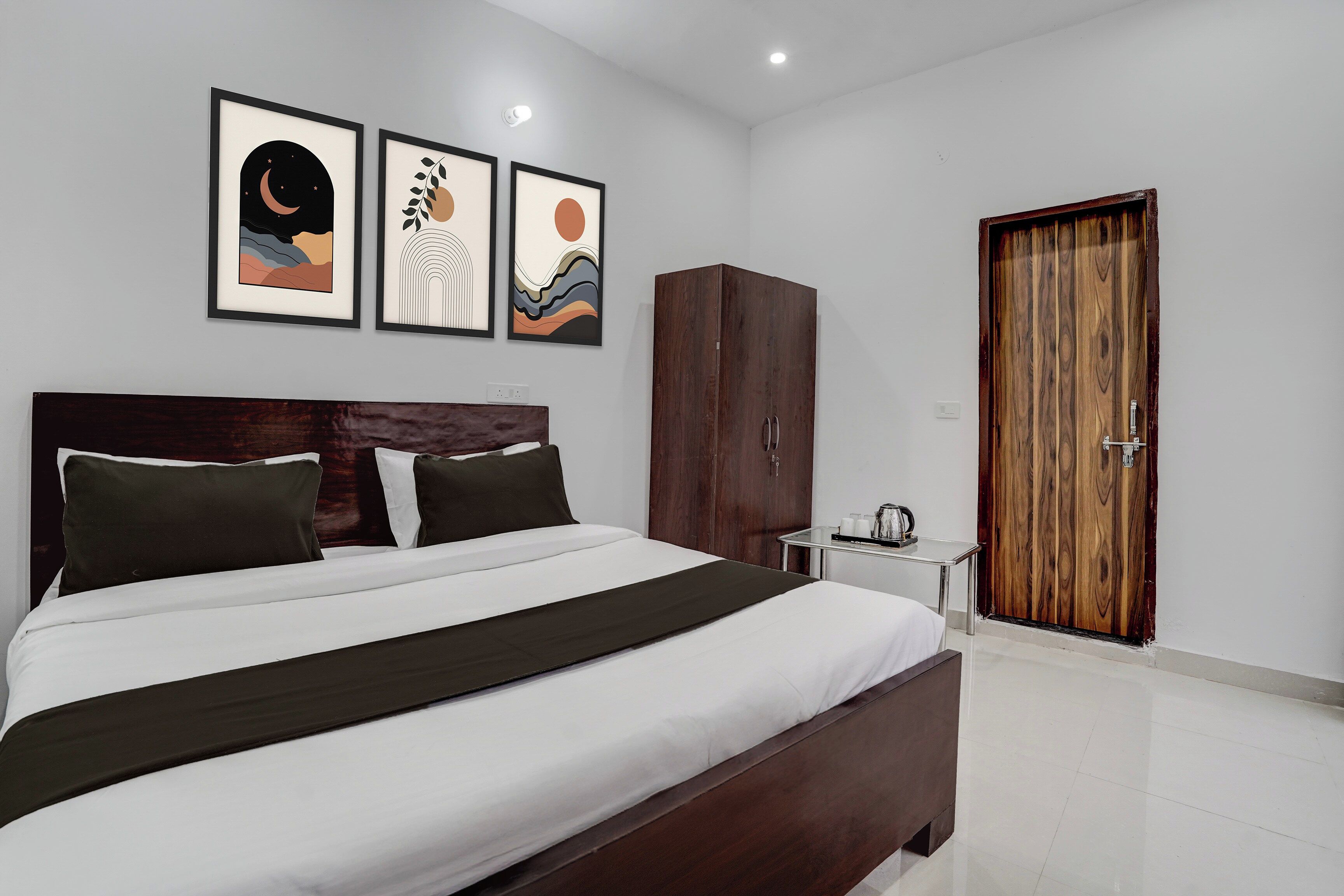 Un dormitorio con una cama, un armario, una mesita de noche y una puerta.