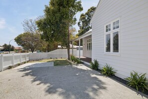A residential property with a paved driveway, a white fence, and a large tree. - Three-Bed Vic Park Haven (Victoria Park)